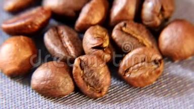 棕色的芳香咖啡颗粒在桌子上<strong>粗布</strong>的基材上旋转。